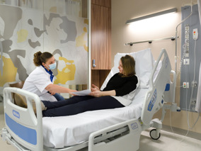 AYA zorg vrouw op bed met brochure